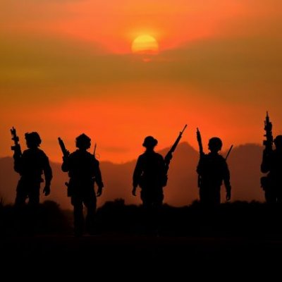 A group of soldiers with weapons silhouetted against a smoky red sky